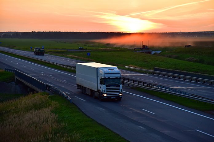 Semi-trailer,Truck,Scania,By,Driving,Along,Highway,On,Sunset,Background.